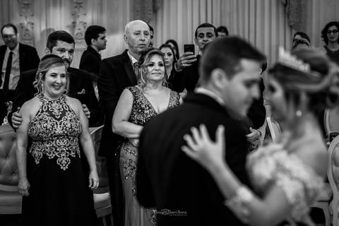 dança dos noivos padrinhos e convidados observam ao fundo preto e branco'