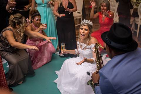 noiva dança junto a madrinhas segura taça de champanhe canta com saxofonista banda festa casamento'