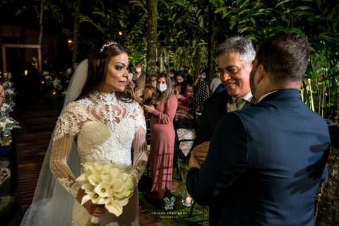 noivo abraça pai da noiva frente ao altar '