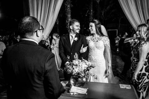 noivos altar sorrindo de frente ao pastor preto e branco'