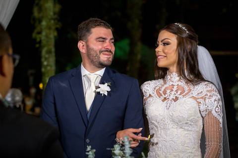 noivos se observam sorrindo no altar frente ao pastor'
