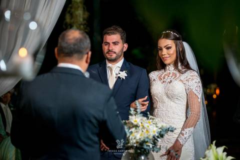 noivos atentos a cerimônia no altar frente ao pastor'