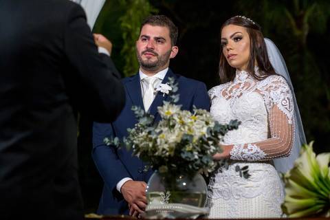 noivos atentos a cerimônia no altar frente ao pastor'