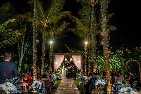 noivos no altar ambiente externo vegetação ao fundo palmeiras convidados'