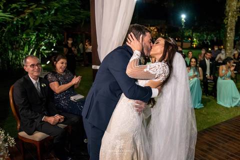 beijo dos noivos noiva vestido véu buque  padrinhos e convidados aplaudem'