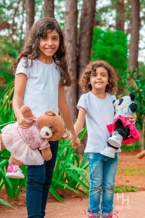 Fotografia infantil no jardim botânico de brasília foto de irmãs com urso de pelúcia na natureza em brasília ensaio infantil em brasília foto de crianças sorrindo na natureza fotografia infantil ensaio infantil no jardim botânico de brasília '