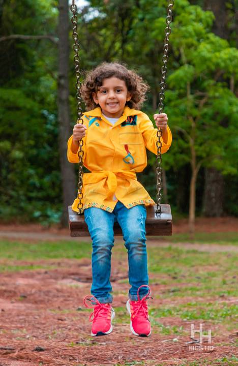 Fotografia infantil no jardim botânico de brasília foto em balanço no jardim na natureza em brasília ensaio infantil em brasília foto de criança sorrindo no balanço na natureza fotografia infantil ensaio infantil temático no jardim botânico de brasília '