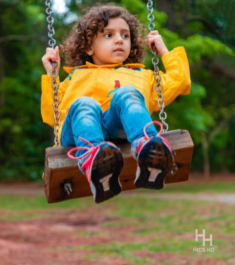 Fotografia infantil no jardim botânico de brasília foto em balanço no jardim na natureza em brasília ensaio infantil em brasília foto de criança sorrindo no balanço na natureza fotografia infantil ensaio infantil temático no jardim botânico de brasília '