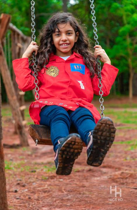 Fotografia infantil no jardim botânico de brasília foto em balanço no jardim na natureza em brasília ensaio infantil em brasília foto de criança sorrindo no balanço na natureza fotografia infantil ensaio infantil temático no jardim botânico de brasília '