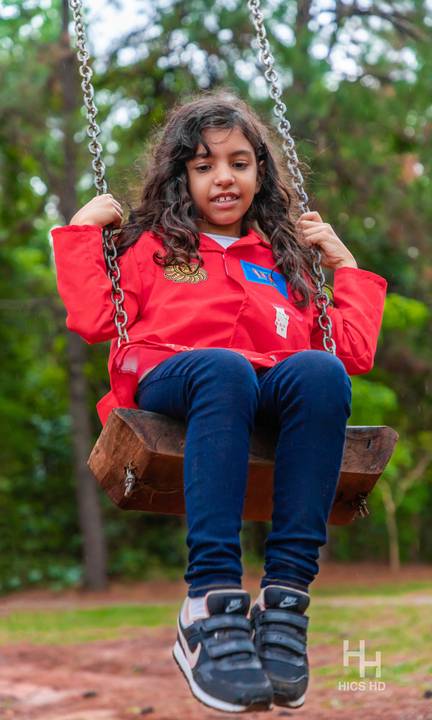 Fotografia infantil no jardim botânico de brasília foto em balanço no jardim na natureza em brasília ensaio infantil em brasília foto de criança sorrindo no balanço na natureza fotografia infantil ensaio infantil temático no jardim botânico de brasília '