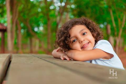Fotografia infantil no jardim botânico de brasília foto de criança sentada no banco na natureza em brasília ensaio infantil em brasília foto de criança sorrindo na natureza fotografia infantil espontânea ensaio infantil no jardim botânico de brasília '
