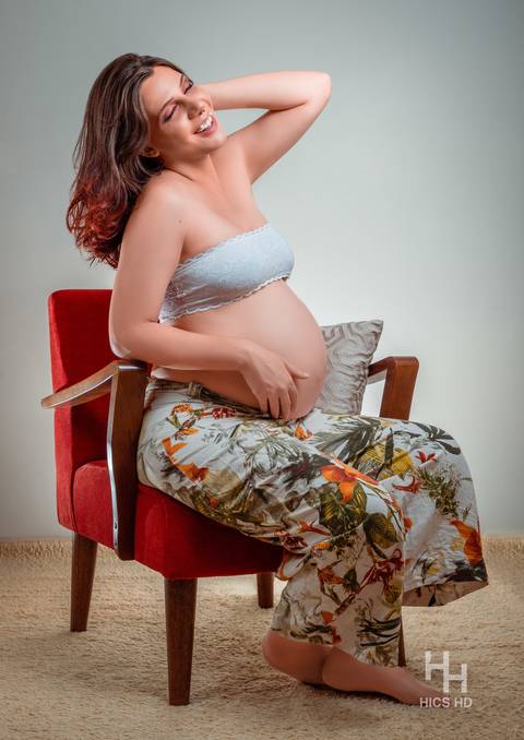 Ensaio gestante Brasília ensaio gestante dentro de casa ensaio maternidade ensaio indoor ensaio interno em Brasília ensaio de gestante sentada em poltrona e sorrindo para o alto ensaio de gravidez  foto de gestante em estúdio em Brasília'