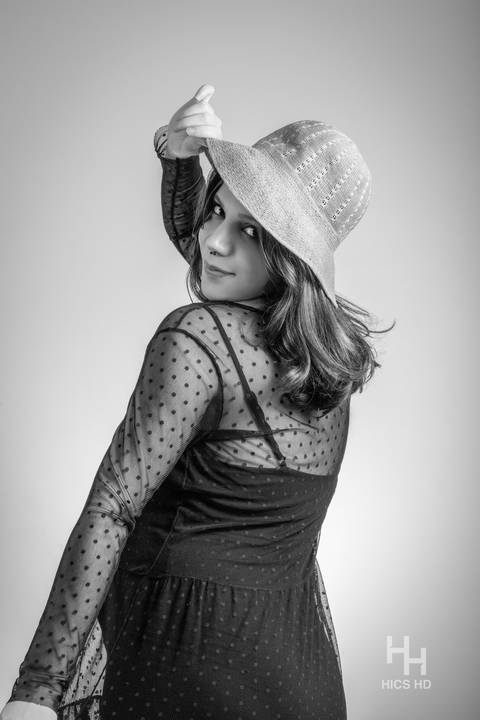 ensaio indoor ensaio interno em Brasília ensaio de gestante com chapéu no fundo branco ensaio em estúdio Brasília ensaio de gravidez foto de gestante em preto e branco segurando chapéu ensaio de gravidez'