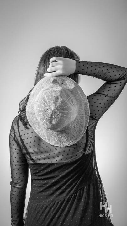 ensaio indoor ensaio interno em Brasília ensaio de gestante com chapéu no fundo branco ensaio em estúdio Brasília ensaio de gravidez foto de gestante em preto e branco segurando chapéu ensaio de gravidez'