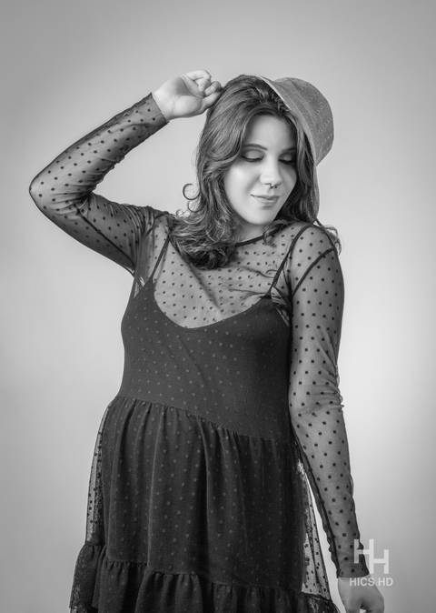 ensaio indoor ensaio interno em Brasília ensaio de gestante com chapéu no fundo branco ensaio em estúdio Brasília ensaio de gravidez foto de gestante em preto e branco segurando chapéu ensaio de gravidez Brasília'