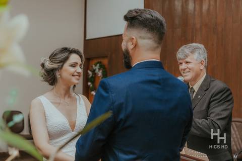 fotografia de casamento na igreja casal na cerimônia de casamento na igreja em brasília cobertura fotográfica de casamento cristão fotografia de casamento em brasília foto da pregação  de casamento no púlpito foto do casal e pastor sorrindo na cerimônia'