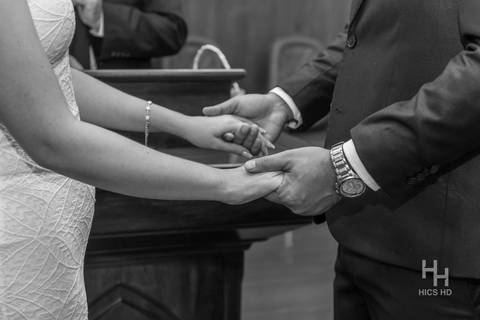 fotografia de casamento na igreja casal na cerimônia de casamento na igreja em brasília cobertura fotográfica de casamento casamento cristão fotografia de casamento em brasília foto do casal no púlpito segurando as mãos close das mãos em preto e branco'
