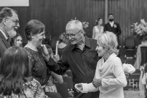 fotografia de casamento na igreja casal na cerimônia de casamento na igreja em brasília cobertura fotográfica de casamento cristão fotografia de casamento em brasília foto dos pais do noivo saindo da igreja após o fim da cerimônia em preto e branco'