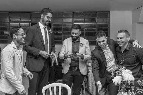 fotografia de casamento na igreja padrinhos na cerimônia de casamento na igreja em brasília cobertura fotográfica de casamento cristão fotografia de casamento em brasília foto dos padrinhos vendendo a gravata na recepção após cerimônia de casamento'