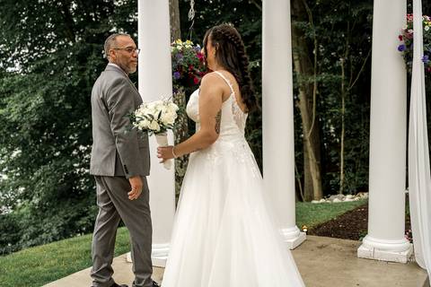 A lively wedding ceremony at The Waterview in Monroe, CT. A groomsman joyfully hands out beers to smiling guests, setting a fun and unique tone that perfectly matches the joyful personalities of Briana & Nicholas.'