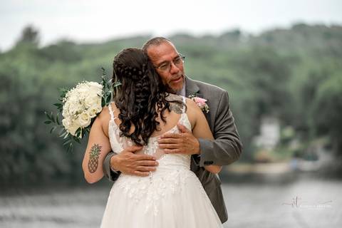 Briana & Nicholas share a joyful moment during their wedding at The Waterview in Monroe, CT. Surrounded by friends and family, they stand hand in hand, beaming with happiness as they exchange vows under a beautifully decorated arch'