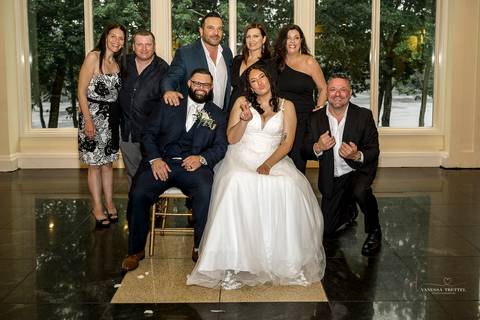 A lively wedding ceremony at The Waterview in Monroe, CT. A groomsman joyfully hands out beers to smiling guests, setting a fun and unique tone that perfectly matches the joyful personalities of Briana & Nicholas.'