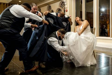 Briana & Nicholas share a joyful moment during their wedding at The Waterview in Monroe, CT. Surrounded by friends and family, they stand hand in hand, beaming with happiness as they exchange vows under a beautifully decorated arch'