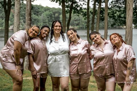 Briana & Nicholas share a joyful moment during their wedding at The Waterview in Monroe, CT. Surrounded by friends and family, they stand hand in hand, beaming with happiness as they exchange vows under a beautifully decorated arch'