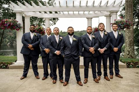Briana & Nicholas share a joyful moment during their wedding at The Waterview in Monroe, CT. Surrounded by friends and family, they stand hand in hand, beaming with happiness as they exchange vows under a beautifully decorated arch'