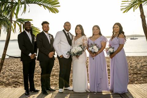 Captured in the soft glow of the setting sun, Jessica & Ben share a kiss at Anthony's Ocean View. The ocean and the vibrant sunset create a romantic atmosphere, making this moment feel truly magical.'