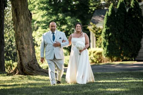 Amanda and Vinny walking hand in hand through the gardens at Woodwinds, sharing a quiet, joyful moment as they head toward the reception.

'