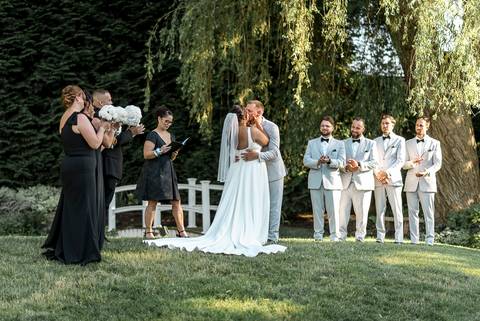 The whole family posing together in front of the reception venue at Woodwinds, dressed in elegant wedding attire, radiating happiness.'
