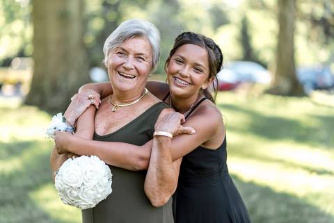 Their daughter sharing a sweet moment with her grandmother, holding hands and smiling warmly at each other during the wedding celebration at Woodwinds.'