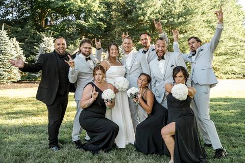 The whole family posing together in front of the reception venue at Woodwinds, dressed in elegant wedding attire, radiating happiness.'