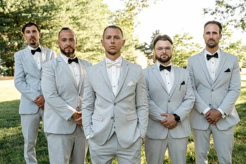 The whole family posing together in front of the reception venue at Woodwinds, dressed in elegant wedding attire, radiating happiness.'