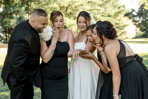 The whole family posing together in front of the reception venue at Woodwinds, dressed in elegant wedding attire, radiating happiness.'