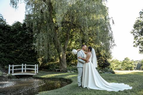 Romantic shot of Amanda and Vinny sharing a quiet moment by the fountain at Woodwinds, foreheads touching and eyes closed.'
