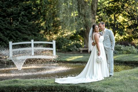 Romantic shot of Amanda and Vinny sharing a quiet moment by the fountain at Woodwinds, foreheads touching and eyes closed.'