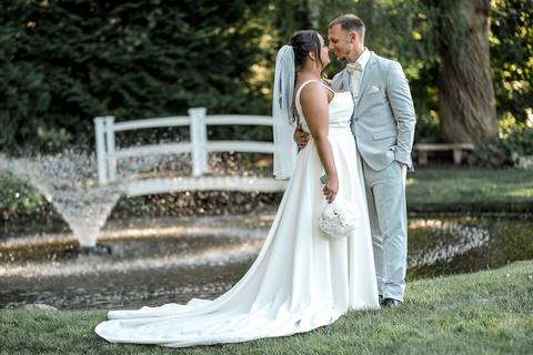 Romantic shot of Amanda and Vinny sharing a quiet moment by the fountain at Woodwinds, foreheads touching and eyes closed.'