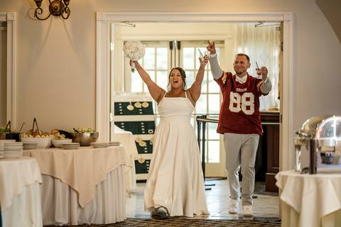 Amanda and Vinny walking hand in hand through the gardens at Woodwinds, sharing a quiet, joyful moment as they head toward the reception.
'