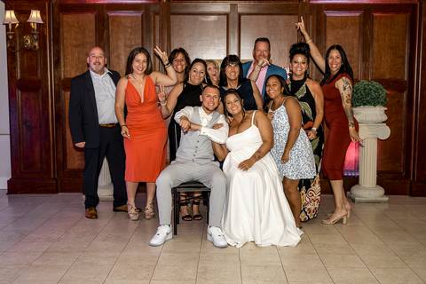 Amanda and Vinny surrounded by their family, all smiling and gathered together for a heartfelt group photo at Woodwinds, celebrating their special day.

'