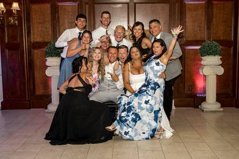 Amanda and Vinny surrounded by their family, all smiling and gathered together for a heartfelt group photo at Woodwinds, celebrating their special day.

'