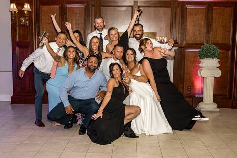 Amanda and Vinny surrounded by their family, all smiling and gathered together for a heartfelt group photo at Woodwinds, celebrating their special day.

'