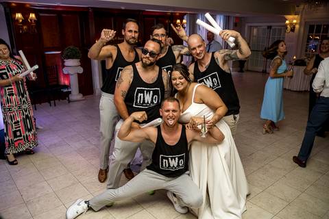 Bridesmaids and groomsmen letting loose on the dance floor, captured mid-laugh in a lively celebration moment.'