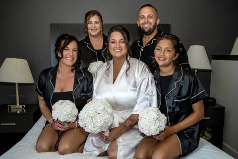 The bride and her bridesmaids gathered at Woodwinds, sharing laughter and special moments together, surrounded by the lush greenery and the warm glow of the summer afternoon.'