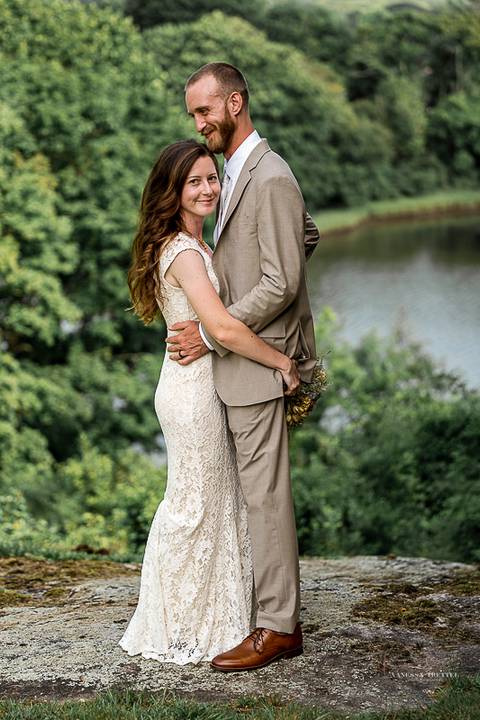 Candid moment of bride laughing with bridesmaids before the ceremony, sunlight streaming through the trees. Natural wedding photography in CT.'