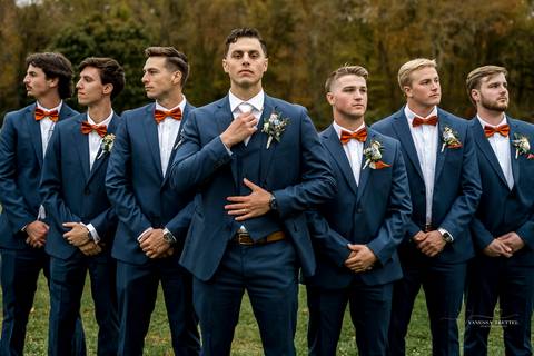 Cara and Daniel pose in front of a backdrop of fiery fall foliage at StoneHurst, their smiles glowing as they hold hands, framed by nature’s colorful embrace on a perfect autumn day.'