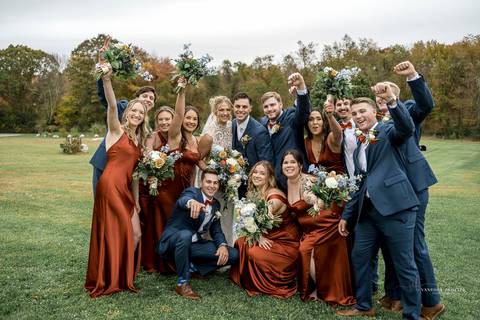 The couple shares a kiss under the golden autumn sunlight at StoneHurst at Hampton Valley, with vibrant foliage surrounding them, capturing the essence of their beautiful fall wedding in CT'