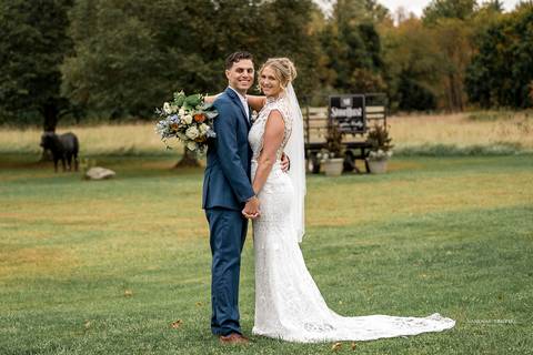 Inside the historic St. James Catholic Church in Danielson, CT, Cara and Daniel exchange vows beneath the grand arches, with soft light filtering through the stained glass, highlighting the moment's intimacy.'
