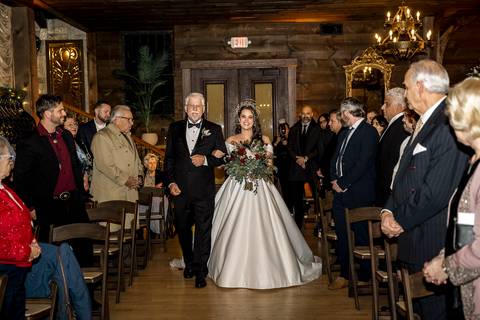 A heartfelt moment as Laura and Lee exchange vows under the soft glow of winter light, surrounded by rustic charm and the warmth of their loved ones in Branford, CT.'